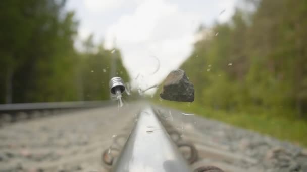 Bombilla de luz se rompe por la piedra en el ferrocarril en cámara lenta — Vídeos de Stock