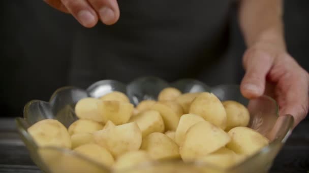 Mann pfeffert Kartoffeln in der dunklen Küche — Stockvideo