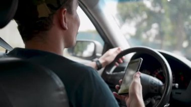 Erkek sürücü arabada oturan ve harita gps navigasyon ile akıllı telefon tutarak