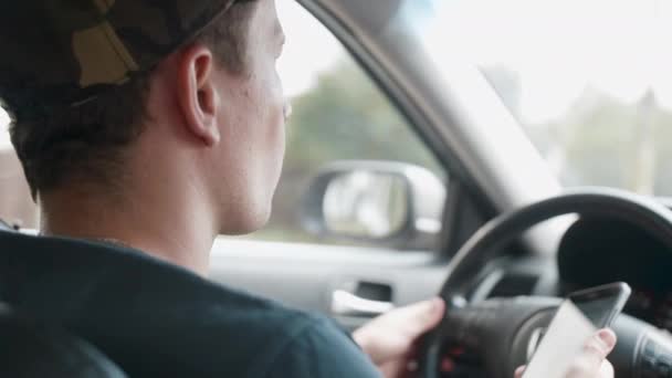 Conductor masculino sentado en el coche y sosteniendo el teléfono inteligente con navegación GPS mapa — Vídeo de stock