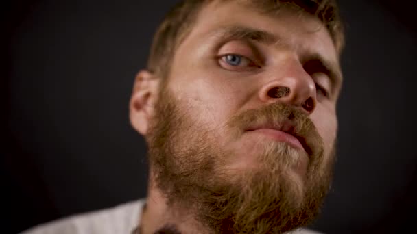 Handsome bearded hipster male shaves in the black dark room — Stock Video