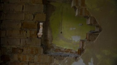 Terk edilmiş binanın duvarındaki delikten, döndürülmüş bakış açısı