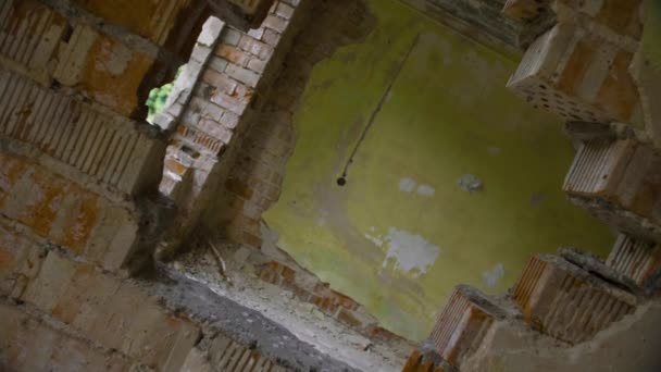 Através do buraco na parede do edifício abandonado, ponto de vista girado — Vídeo de Stock
