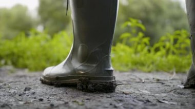 Kirli yerde çamur iş ile kauçuk yağmur çizme kapatın