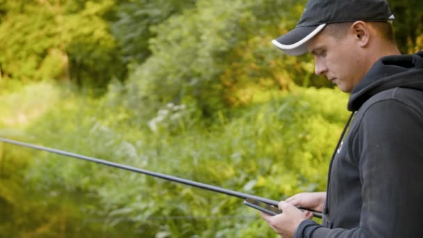 Pescatore che pesca in un fiume con una canna da pesca — Video Stock