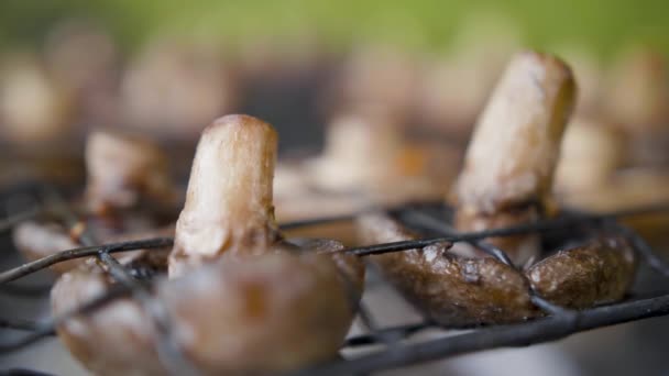 Mushrooms brown champignon cooked on grill or barbecue outdoors — Stock Video