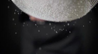 Un siyah arka plan üzerinde bir elek ile elenir