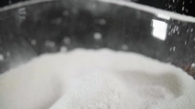 Un siyah arka plan üzerinde bir elek ile elenir