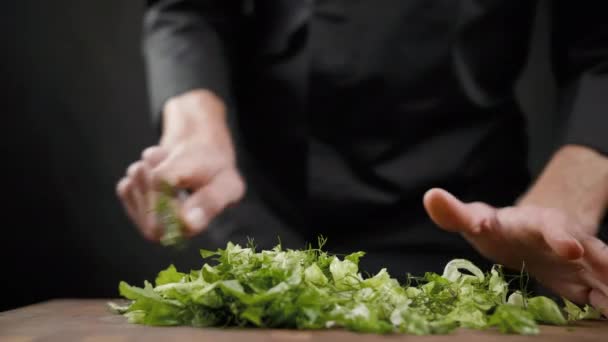 Corte um monte de alface verde para salada na mesa de madeira sobre fundo preto — Vídeo de Stock