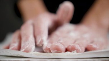 Cook siyah arka plan üzerinde pizza için buğday hamuru hazırlar