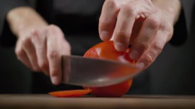 Cook siyah arka plan üzerinde ahşap masada kırmızı domates pirzola