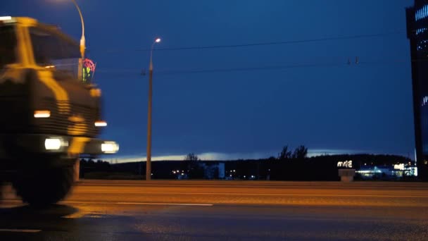 Un convoi de matériel militaire traverse la ville la nuit avec les phares allumés — Video