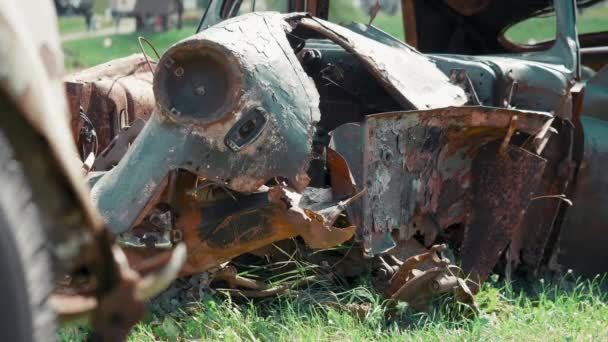 Rusty förstört passagerar bil ligger på en solig sommardag i mitten av fältet — Stockvideo