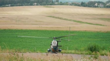 Güneşli bir yaz gününde bir helikopter havalanıyor.