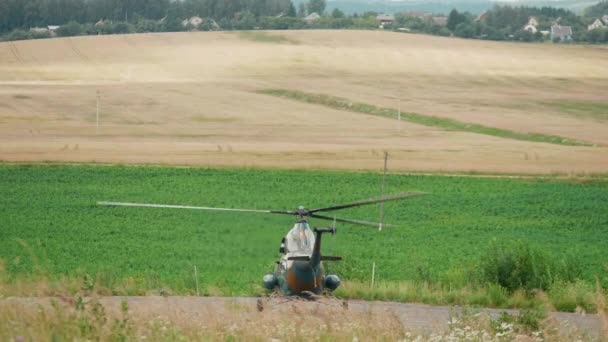 Ein Hubschrauber hebt an einem sonnigen Sommertag vom Feld ab — Stockvideo