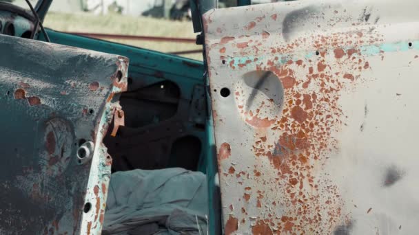 Rusty förstört passagerar bil ligger på en solig sommardag i mitten av fältet — Stockvideo
