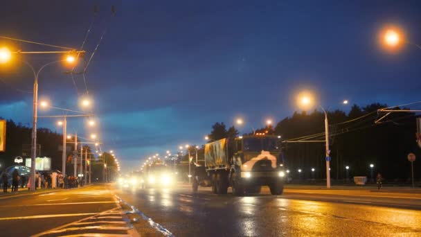 Konwój sprzętu wojskowego jeździ przez miasto nocą z reflektorami na — Wideo stockowe