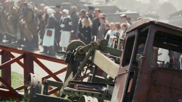 Destroyed rusty car on the background of people in uniform — Stock Video