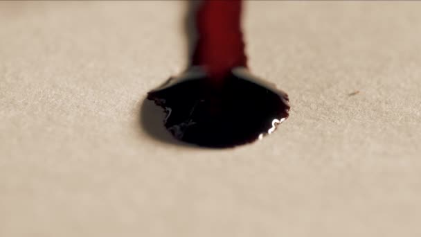 Червоні краплі крові тече на білому папері, макрос — стокове відео