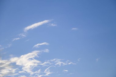 mavi gökyüzü beyaz bulutlar ile akşam. Güneş bulutların arkasına gizler. gün batımında güneş ışınlarının kabarık bulutlar farklı renk aydınlatmak.