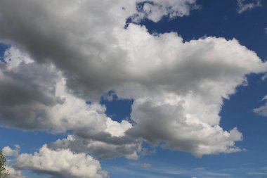 mavi gökyüzü beyaz bulutlar ile akşam. Güneş bulutların arkasına gizler. gün batımında güneş ışınlarının kabarık bulutlar farklı renk aydınlatmak.