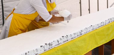 Tereyağı krema ile lezzetli kek dekorasyon pudra. Pudra büyük Festival kek pandispanya krem şanti beyaz krema koymak beyaz eldiven eller.
