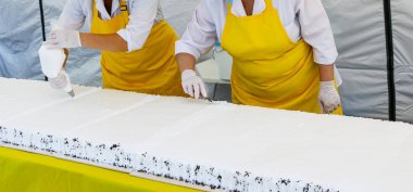 Tereyağı krema ile lezzetli kek dekorasyon pudra. Pudra büyük Festival kek pandispanya krem şanti beyaz krema koymak beyaz eldiven eller.