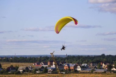 Motor paraplan uçuşu. parlak renkli motoparaplane Köyü, alan ve inşaat site yukarıda adam uçar.