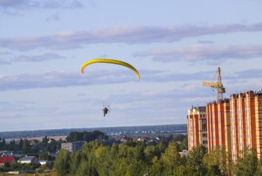 Motor paraplan uçuşu. parlak renkli motoparaplane Köyü, alan ve inşaat site yukarıda adam uçar.