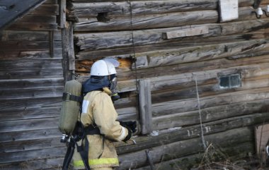 itfaiyeci üniforması giyen, kask ve özel oksijen maskesi için nefes, gaz maskesi ve sıkıştırılmış hava ile balon bir yangından sonra çalışma.