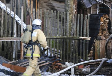itfaiyeci üniforması giyen, kask ve özel oksijen maskesi için nefes, gaz maskesi ve sıkıştırılmış hava ile balon bir yangından sonra çalışma.