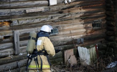 itfaiyeci üniforması giyen, kask ve özel oksijen maskesi için nefes, gaz maskesi ve sıkıştırılmış hava ile balon bir yangından sonra çalışma.