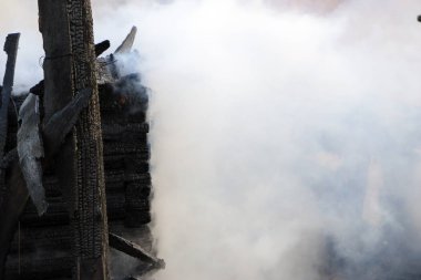 Yangın. kalıntıları ve yanık ahşap ev kalıntıları. Kalın duman yanmış Kömürleşmiş odun.