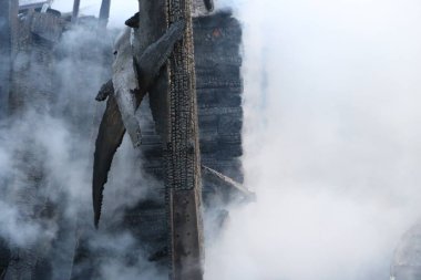Yangın. kalıntıları ve yanık ahşap ev kalıntıları. Kalın duman yanmış Kömürleşmiş odun.