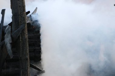 Yangın. kalıntıları ve yanık ahşap ev kalıntıları. Kalın duman yanmış Kömürleşmiş odun.
