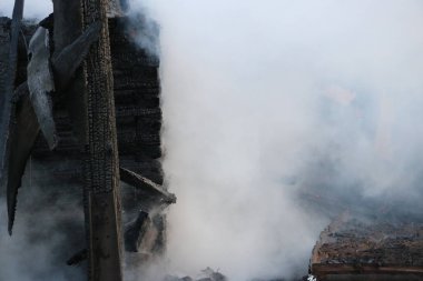 Yangın. kalıntıları ve yanık ahşap ev kalıntıları. Kalın duman yanmış Kömürleşmiş odun.