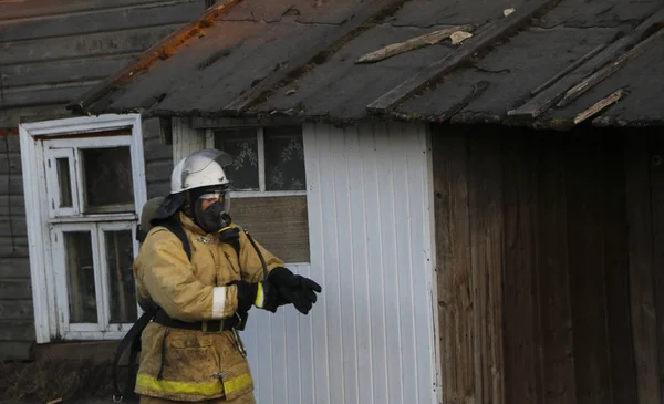 itfaiyeci üniforması giyen, kask ve özel oksijen maskesi için nefes, gaz maskesi ve sıkıştırılmış hava ile balon bir yangından sonra çalışma.