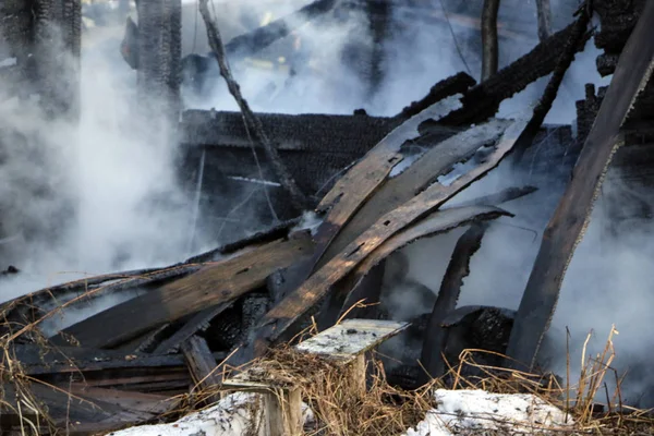 Yangın. kalıntıları ve yanık ahşap ev kalıntıları. Kalın duman yanmış Kömürleşmiş odun.
