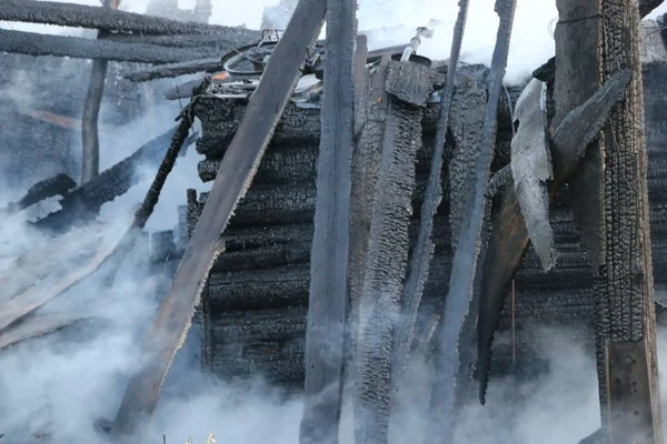 Yangın. kalıntıları ve yanık ahşap ev kalıntıları. Kalın duman yanmış Kömürleşmiş odun.