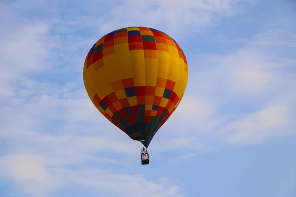 colorful hot air balloon against blue sky. hot air balloon is flying in white clouds. beautiful flying on hot air balloon.
