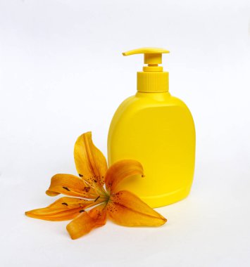 Kozmetik Cilt bakımı için zambak çiçekler ile beyaz bir arka plan üzerinde ayarlayın. kompozisyon Spa, banyo, sauna, duş için. duş sabunu ve duş jeli ile yumuşak cilt temizliği için sarı zambak