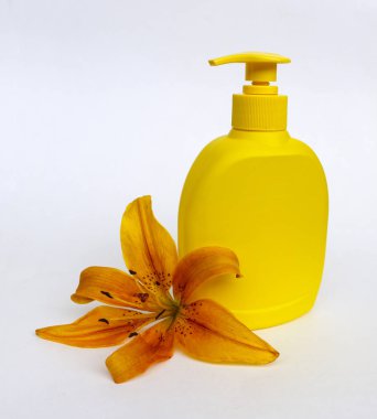 Kozmetik Cilt bakımı için zambak çiçekler ile beyaz bir arka plan üzerinde ayarlayın. kompozisyon Spa, banyo, sauna, duş için. duş sabunu ve duş jeli ile yumuşak cilt temizliği için sarı zambak