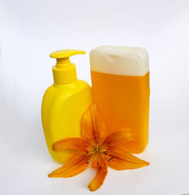 Kozmetik Cilt bakımı için zambak çiçekler ile beyaz bir arka plan üzerinde ayarlayın. kompozisyon Spa, banyo, sauna, duş için. duş sabunu ve duş jeli ile yumuşak cilt temizliği için sarı zambak