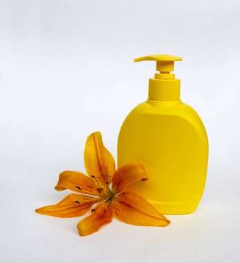 Kozmetik Cilt bakımı için zambak çiçekler ile beyaz bir arka plan üzerinde ayarlayın. kompozisyon Spa, banyo, sauna, duş için. duş sabunu ve duş jeli ile yumuşak cilt temizliği için sarı zambak