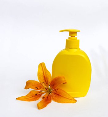 Kozmetik Cilt bakımı için zambak çiçekler ile beyaz bir arka plan üzerinde ayarlayın. kompozisyon Spa, banyo, sauna, duş için. duş sabunu ve duş jeli ile yumuşak cilt temizliği için sarı zambak