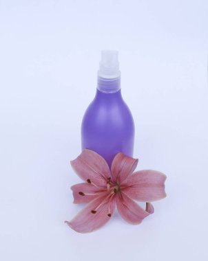 Kozmetik Cilt bakımı için zambak çiçekler ile beyaz bir arka plan üzerinde ayarlayın. kompozisyon Spa, banyo, sauna, duş için. Lila duş şampuan ve duş jeli ile yumuşak cilt temizliği için mor lily.