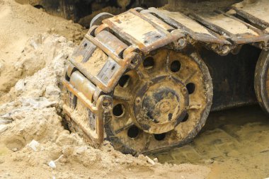 ıslak kum eski demir tırtıl. Paslı çelik jantlar ve caterpillar teyp büyük buldozer, tank, ekskavatör, nemli kum ve su birikintileri.