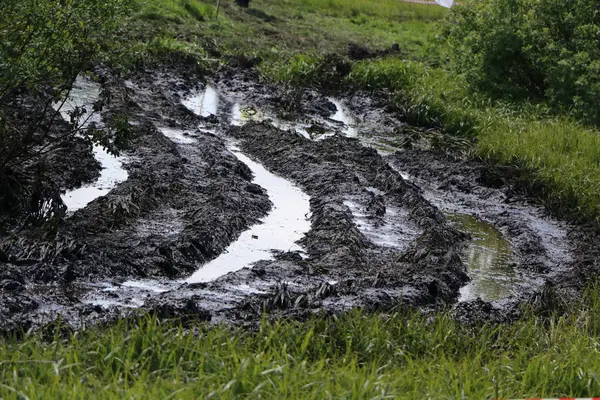 肮脏的乡村道路湿污垢 无法通行 土路上的泥巴和水坑 拖拉机和汽车的痕迹 — 图库照片