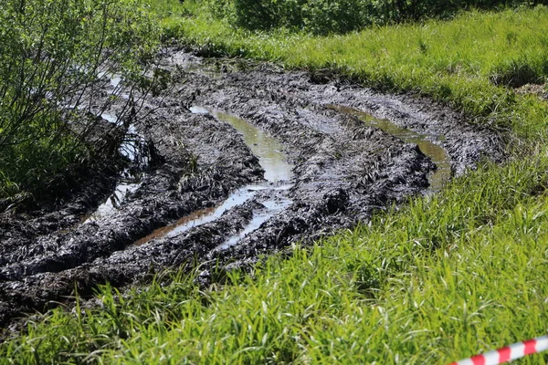 Smutsiga landsväg våt smuts, impassability. lera och vattenpölar på t — Stockfoto