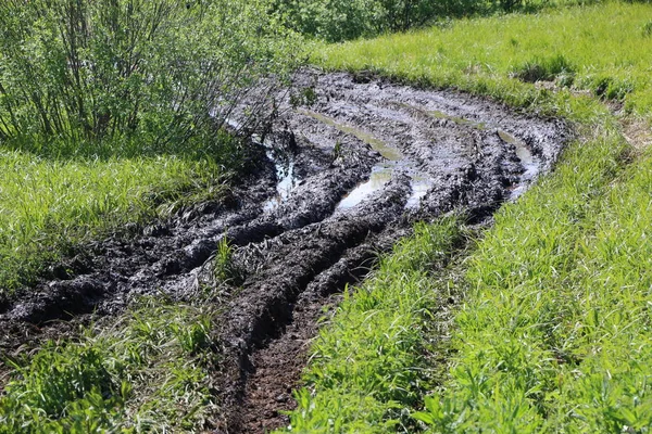 Smutsiga landsväg våt smuts, impassability. lera och vattenpölar på t — Stockfoto